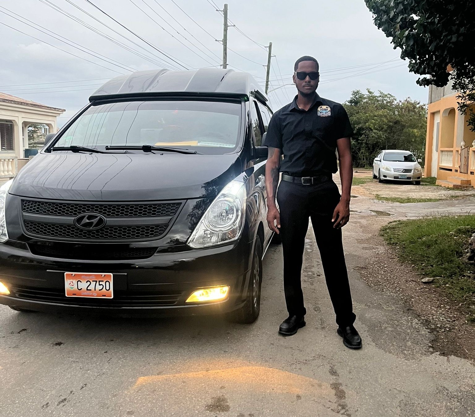 Island Life chauffeur beside the van — Anguilla